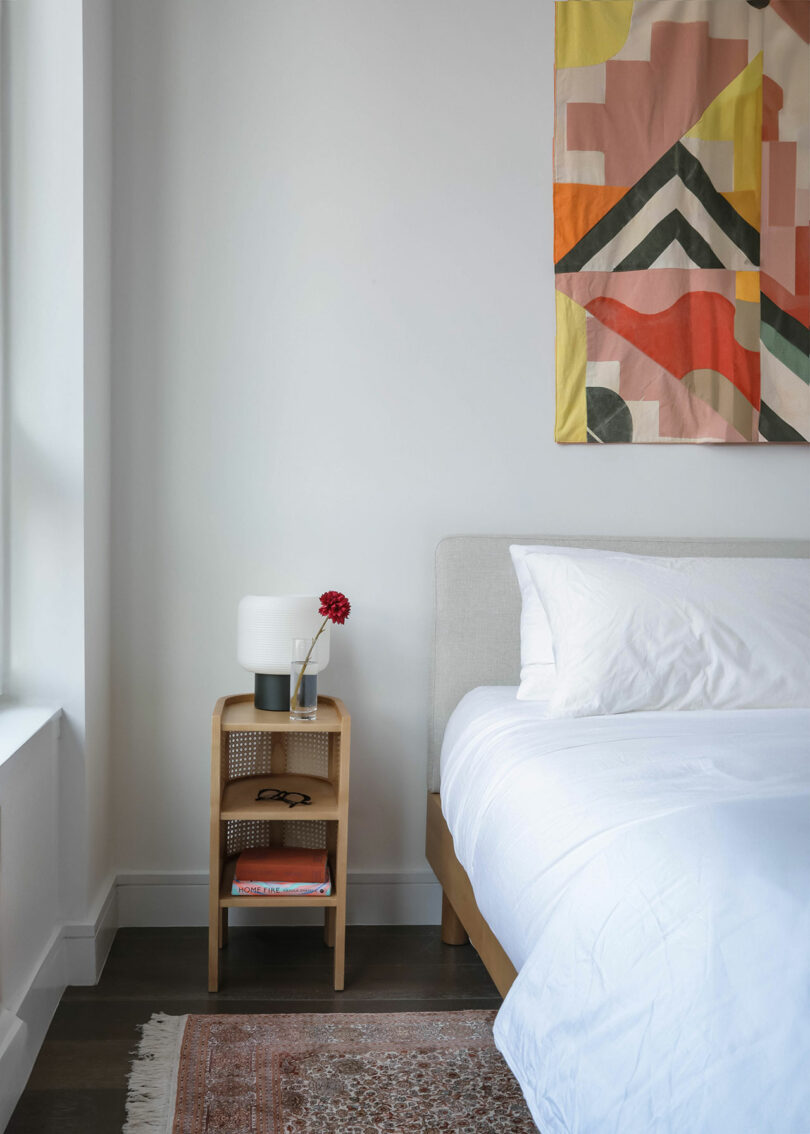 A bed, nightstand and hanging art.