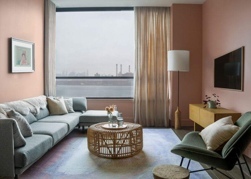 A pink media room with sofa, chair, coffee table, and television.