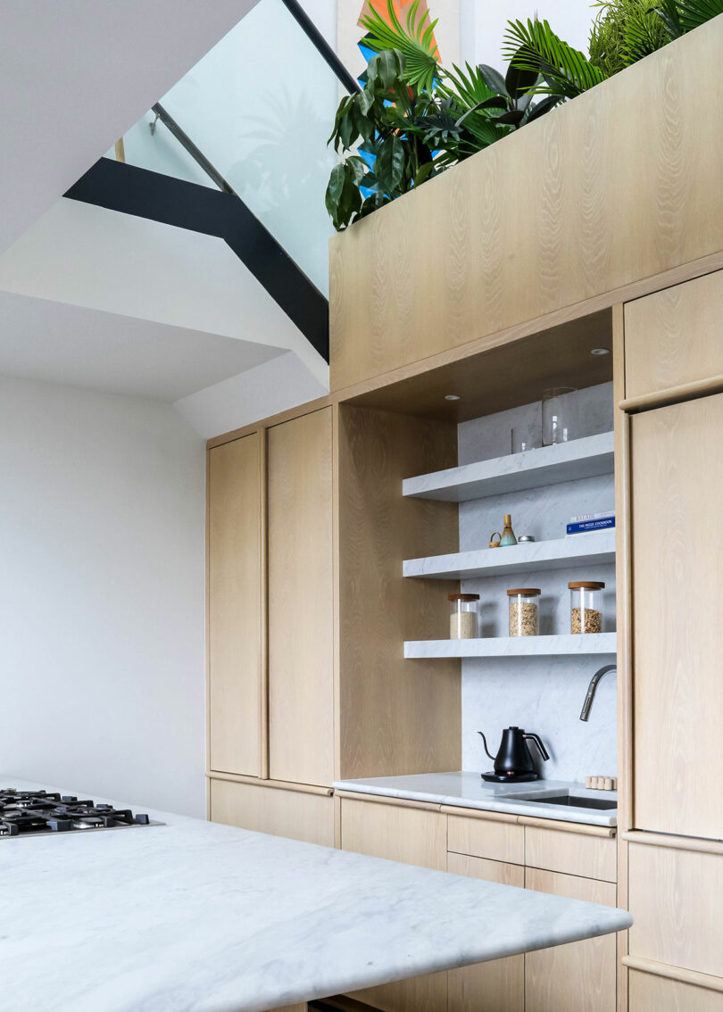 Kitchen cabinets in a light oak, shelving, and center island.