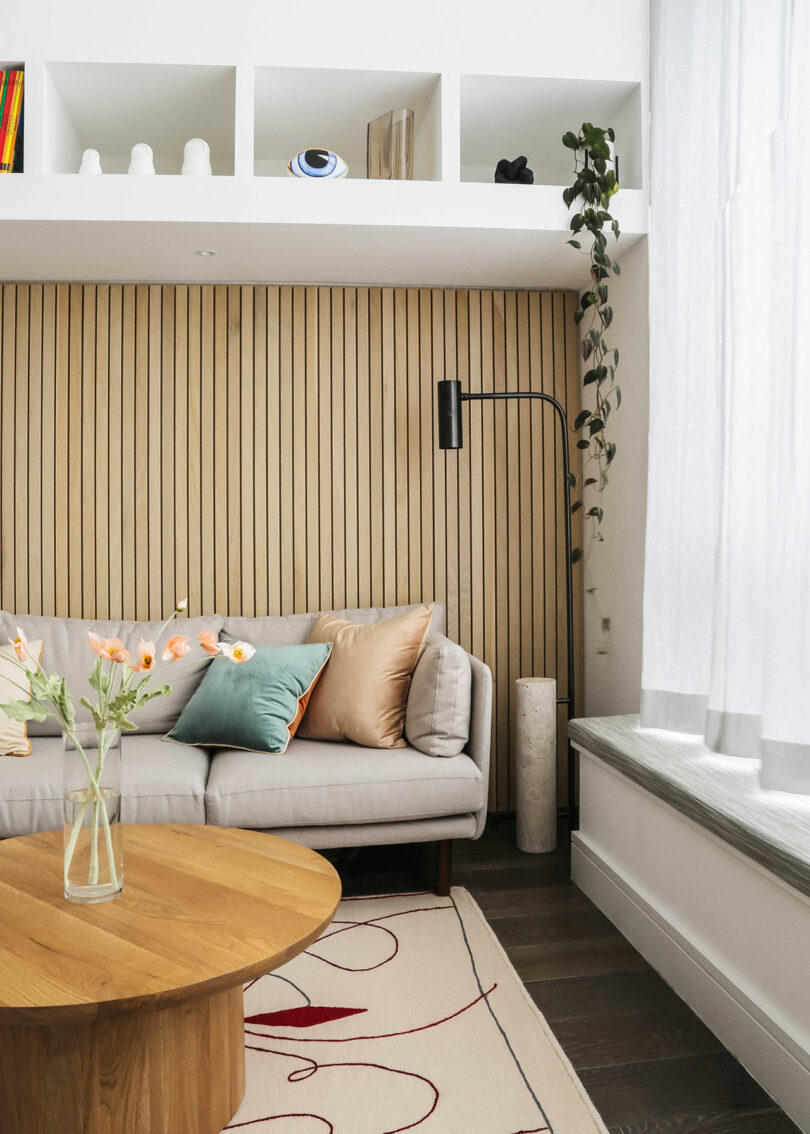 Contemporary, double height living room space with a couch, built-ins, and coffee table.