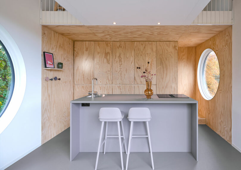 A kitchen with a circular window in the Buitenverblijf Nest.