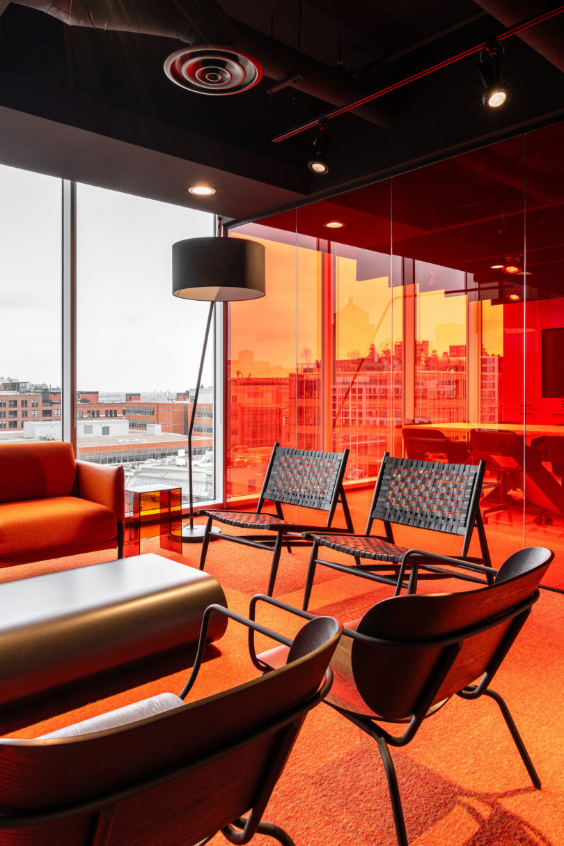 An office with red walls and black furniture.