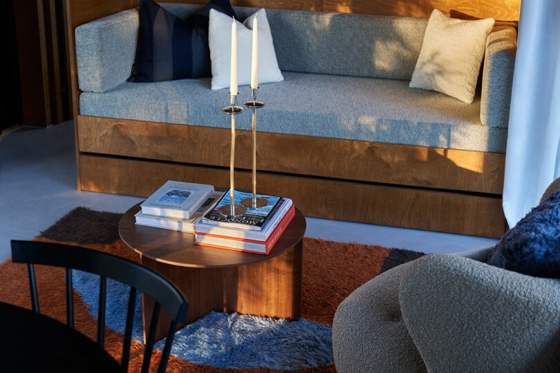 Cozy modern living room bathed in warm sunlight with stylish furnishings and colorful accents.