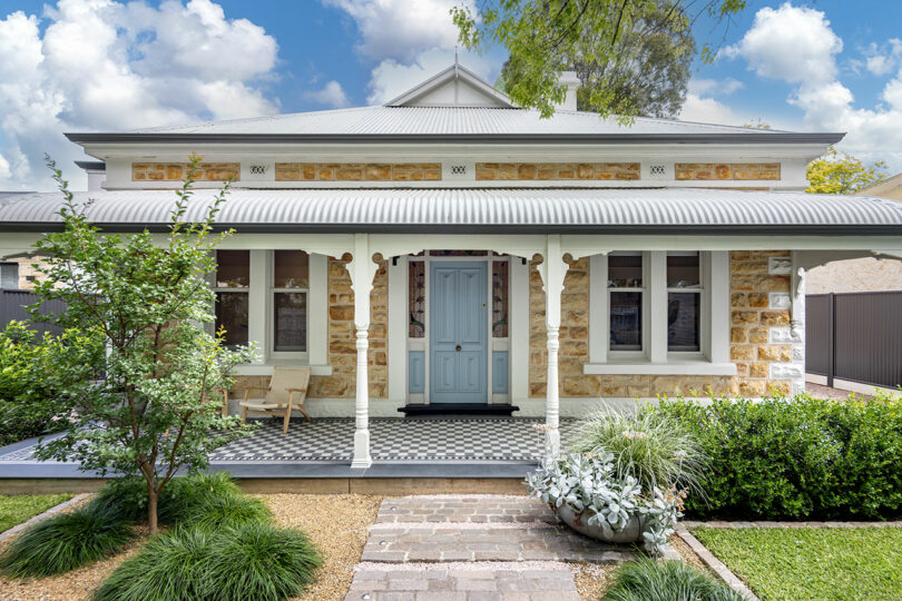 A house with a blue door and a stone wall.