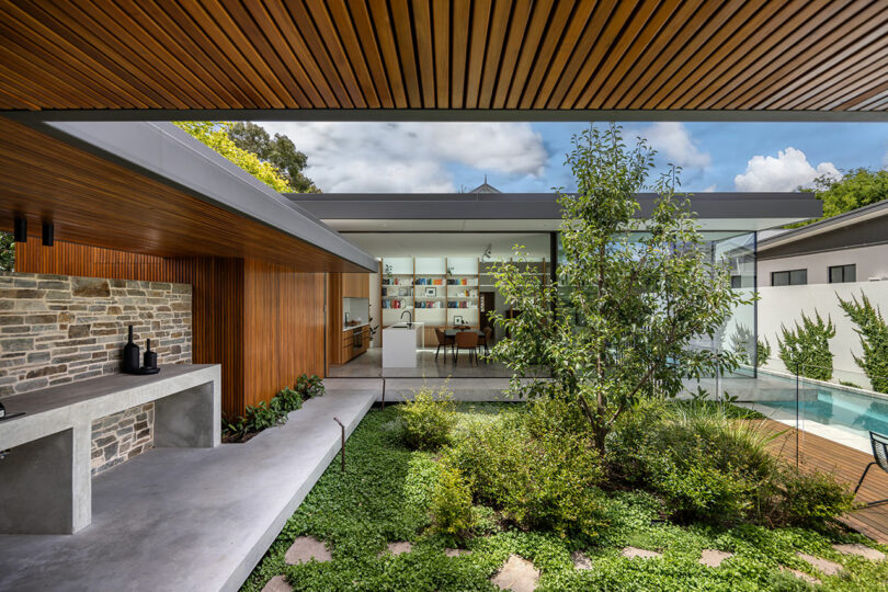 A modern backyard with a wooden deck and a pool.