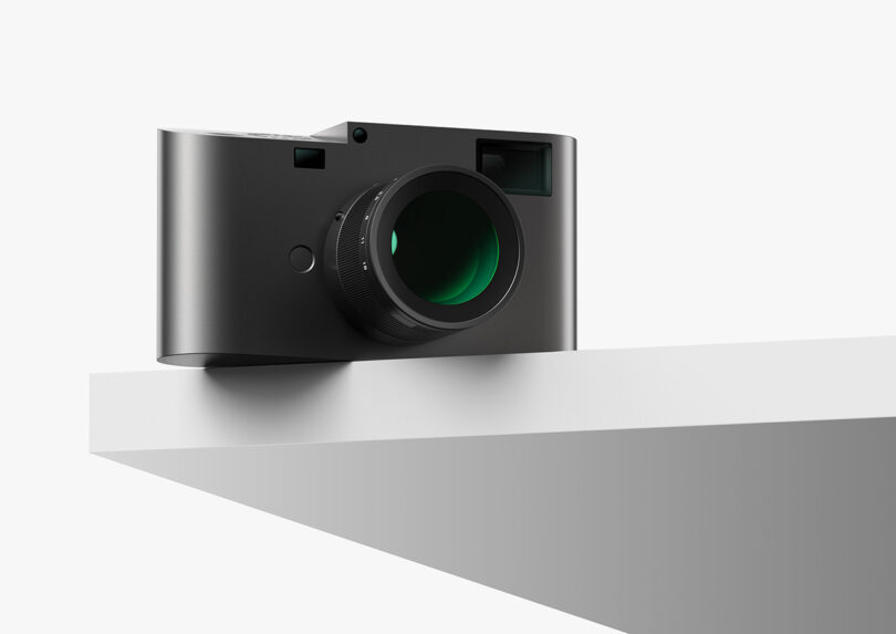 A Leica M Reimagined Concept camera sitting on top and partially off of a shelf.