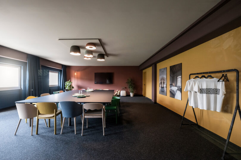 Modern conference room with a long table, eclectic chairs, and NOA artistic decor.