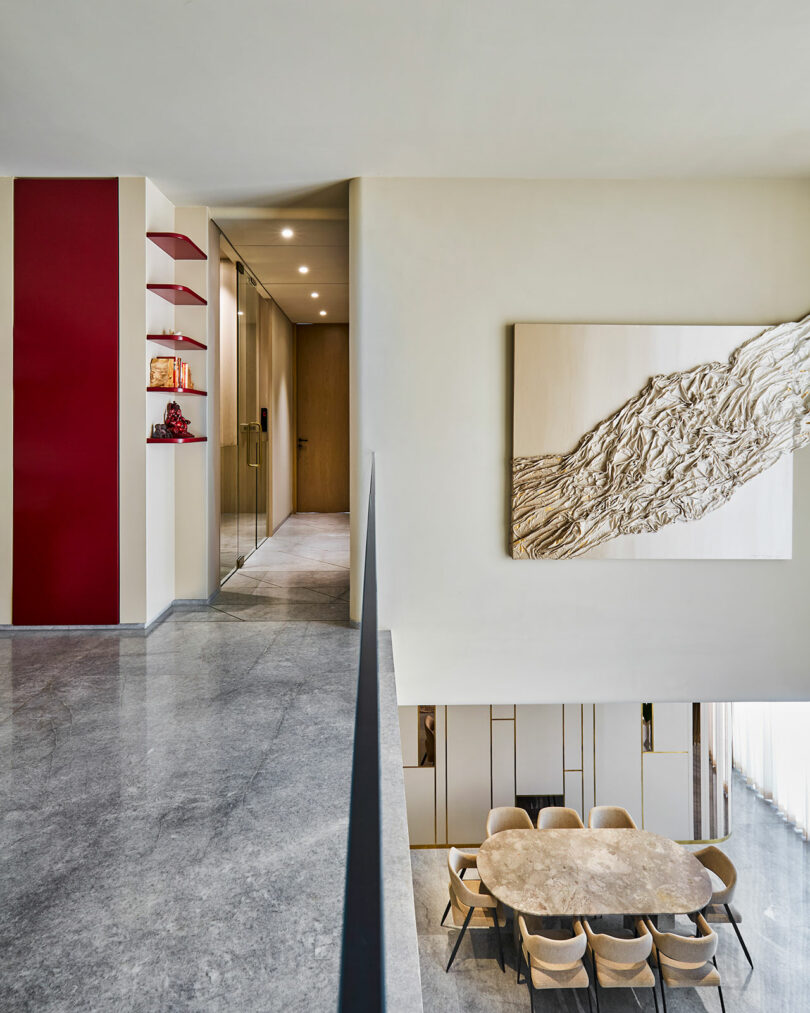 Modern interior with an art, contrasting magenta accents, and a sleek dining area visible down below.