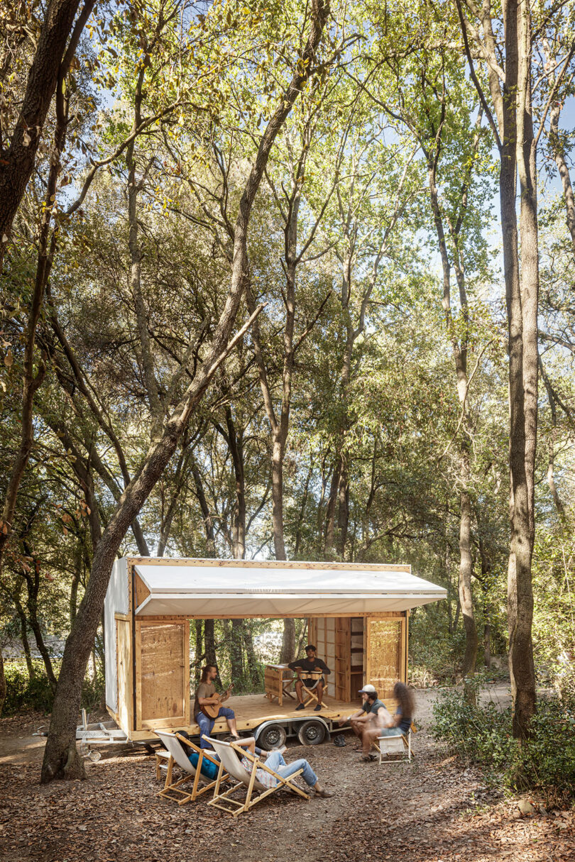 Family enjoying leisure time outside a wooden cabin in the forest.
