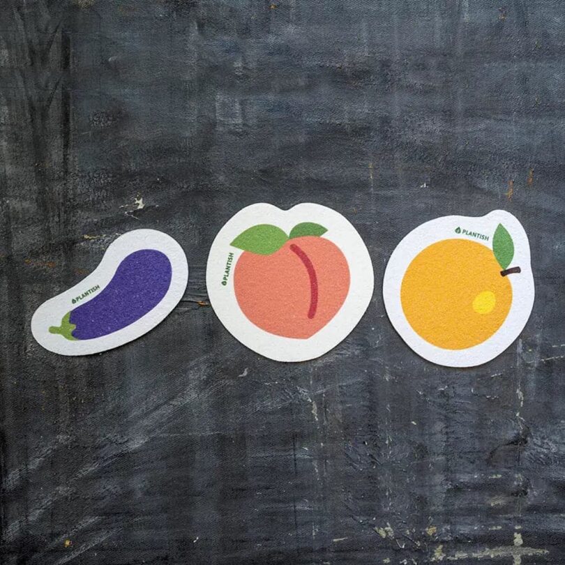 Plantish Pop Up Sponges in an eggplant design, peach design, and orange design, respectively.