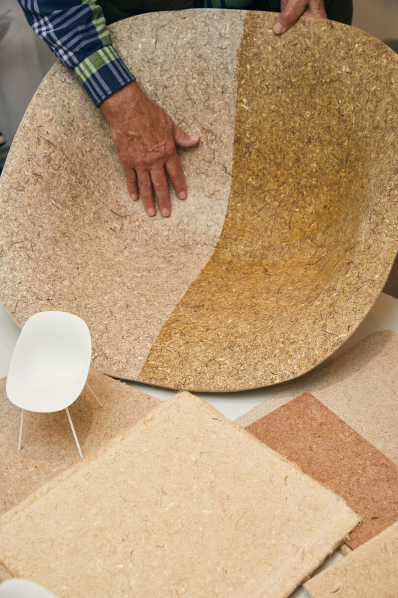 hand holding a chair shell with two finishes